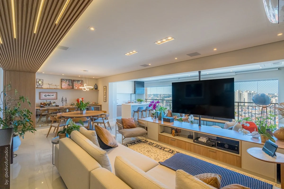 Sala estendida, com painel de TV e varanda ao fundo · Apartamento de 3 suítes com vista livre em Jundiaí