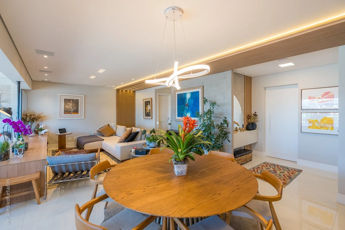 Mesa de jantar sob o pendente, com o estar ao fundo · Apartamento de 3 suítes com vista livre em Jundiaí