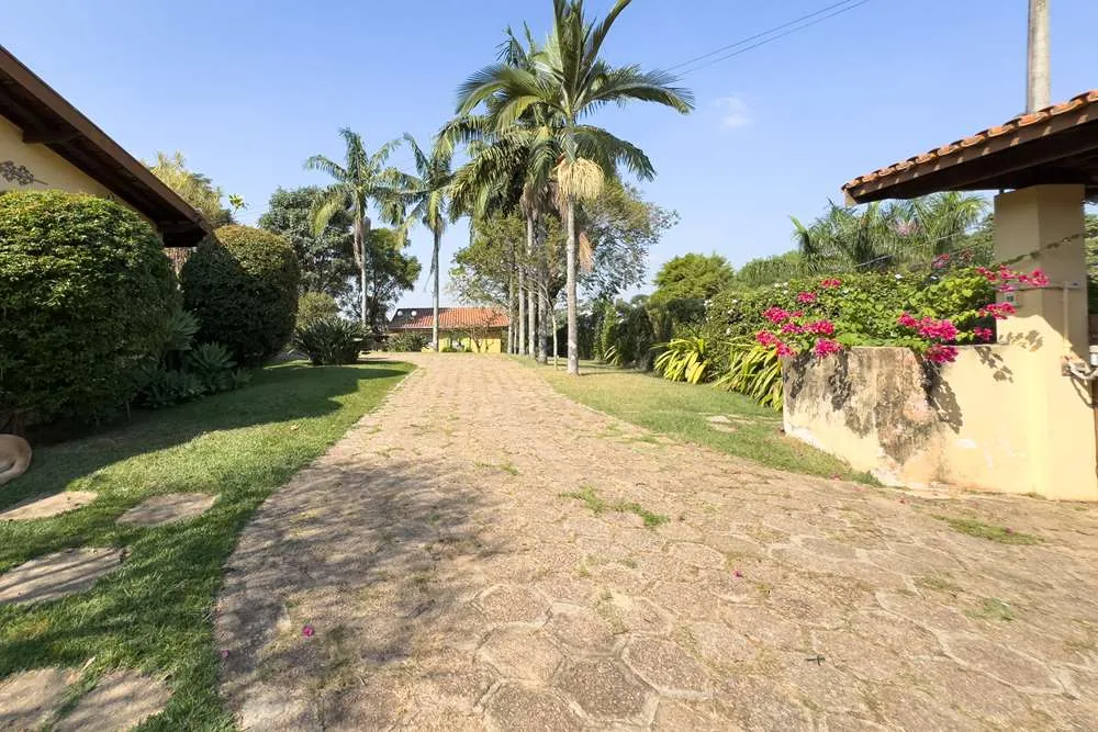 Caminho de pedra e canteiro florido · Casa térrea em terreno arborizado em Vinhedo
