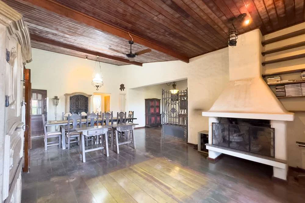 Sala de jantar com lareira e teto de madeira · Casa térrea em terreno arborizado em Vinhedo