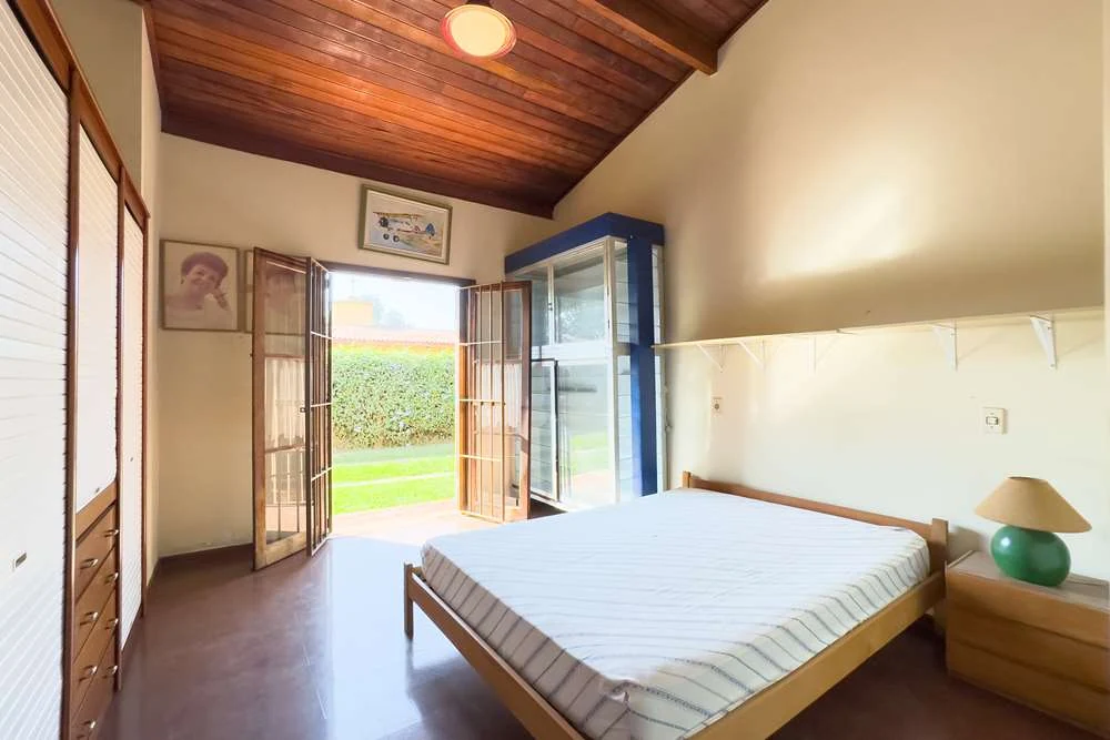 Dormitório com porta para a área externa · Casa térrea em terreno arborizado em Vinhedo