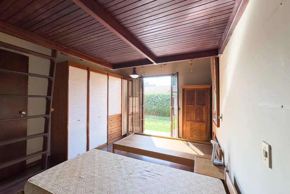 Dormitório com armário e saída para o jardim · Casa térrea em terreno arborizado em Vinhedo