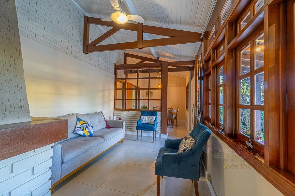 Sala de estar em frente às esquadrias de madeira · Casa em condomínio com 3 suítes em Vinhedo