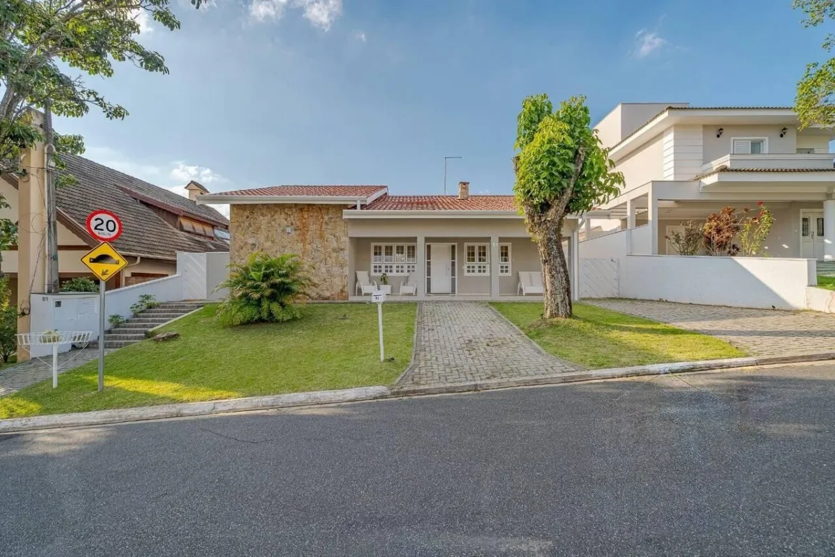 A casa vista da esquina, em rua arborizada do condomínio · Casa térrea com lareira e espaço gourmet em Vinhedo