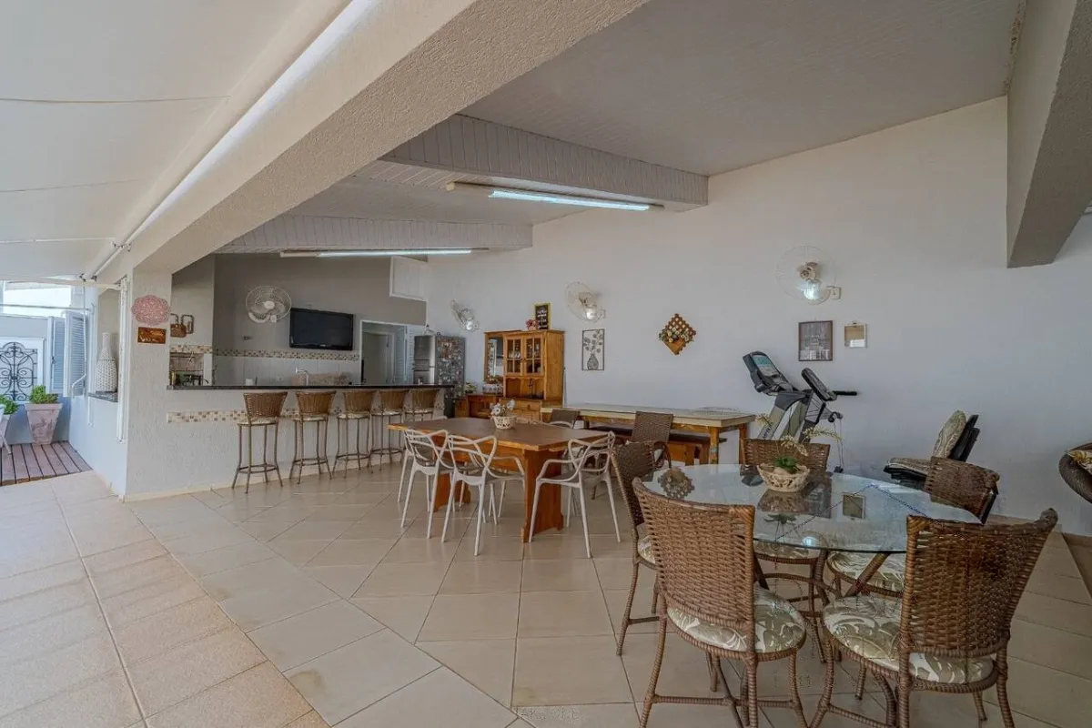 Espaço gourmet com bancada, banquetas e mesas para receber · Casa térrea com lareira e espaço gourmet em Vinhedo
