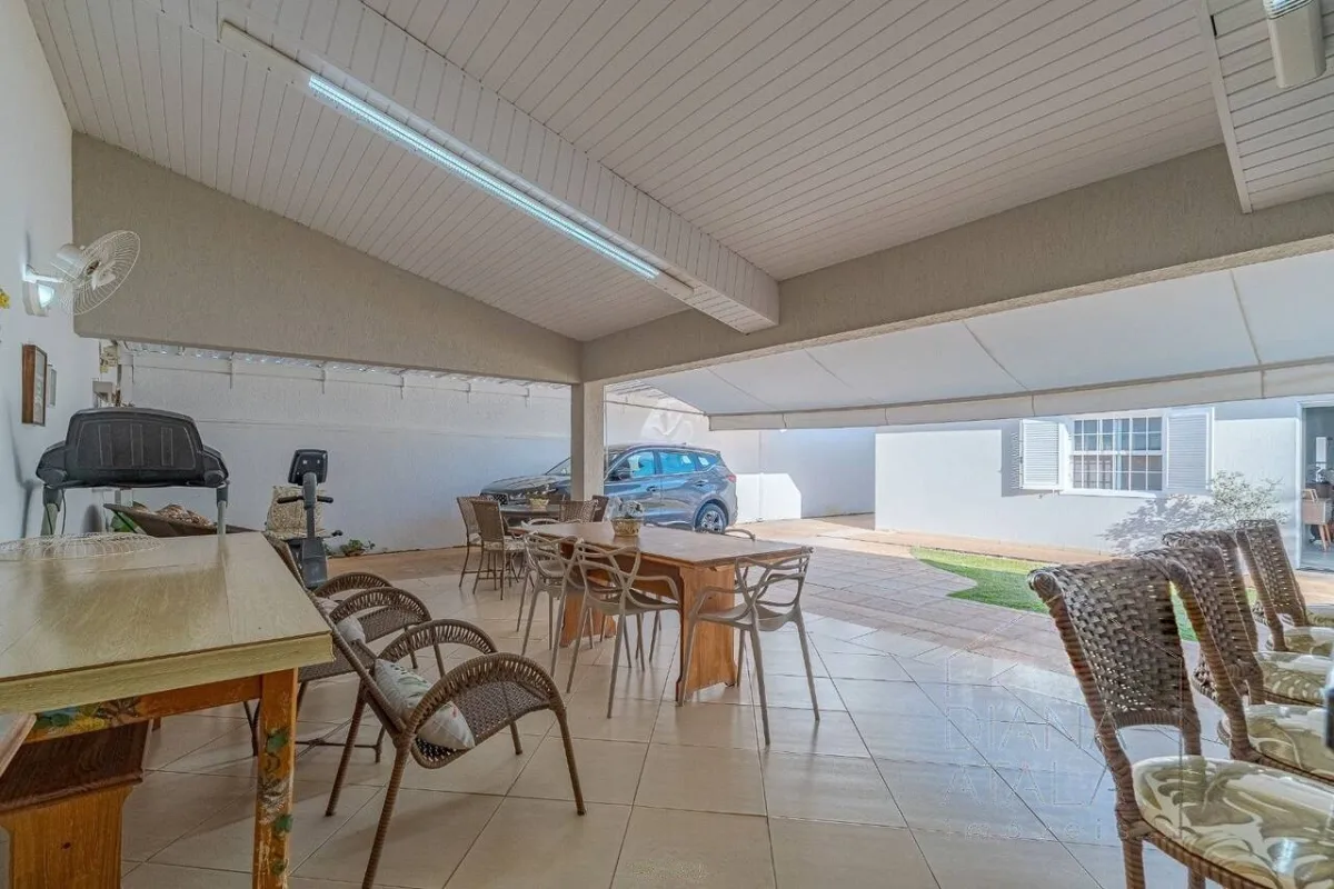 Churrasqueira, mesas e a garagem coberta, tudo no mesmo alpendre · Casa térrea com lareira e espaço gourmet em Vinhedo
